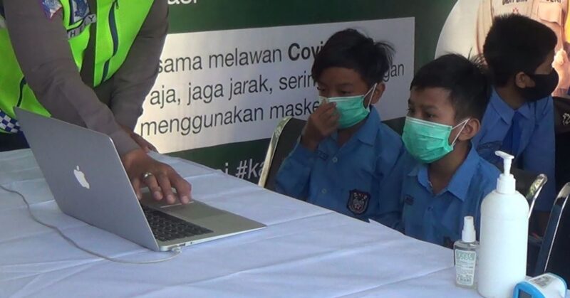 Siswa SD Belajar Daring di Posko Online Sampang Ditemani Polisi