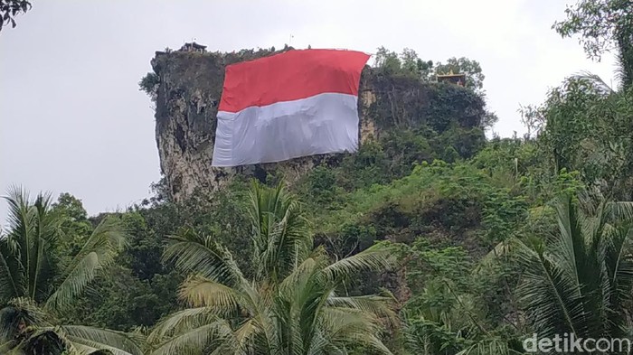 Gelorakan Semangat Patriotisme, Bendera Merah Putih Raksasa Dibentangkan di Tebing Sentono Gentong Pacitan